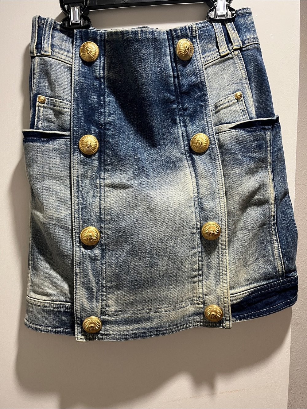 Balmain denim mini skirt features a distinctive double-breasted design adorned w